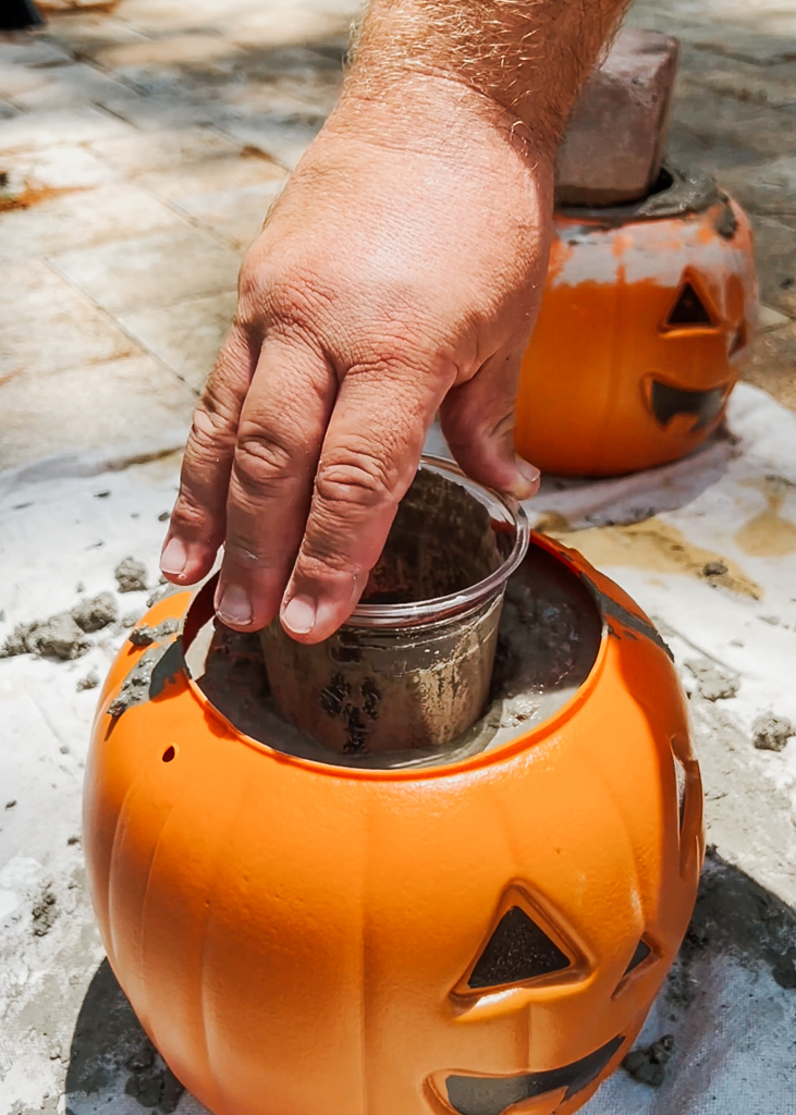Add plastic cup to the center into the wet cement