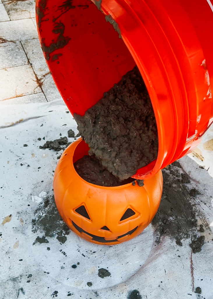 Pour the cement into the plastic pumpkin
